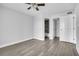 Bright bedroom with gray walls and wood-look floors, featuring a ceiling fan and adjacent bathroom at 1932 Lake Atriums Cir # 69, Orlando, FL 32839