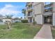 Condo exterior with balconies, stairs, adjacent parking, manicured lawn, and tropical trees against a partly cloudy sky at 1932 Lake Atriums Cir # 69, Orlando, FL 32839