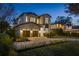 Night view of a modern home with brick exterior and landscaped lawn at 210 E Lake Sue Ave, Winter Park, FL 32789