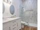 Elegant bathroom with double vanity, marble tile, and walk-in shower at 4510 Packard S Ave, St Cloud, FL 34772