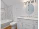 Modern bathroom with white cabinetry, marble tile, and a soaking tub at 4510 Packard S Ave, St Cloud, FL 34772