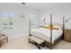 Bright and airy main bedroom with a comfortable four-poster bed and sitting area at 4510 Packard S Ave, St Cloud, FL 34772