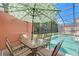 Relaxing pool area with patio furniture, umbrella, and screened enclosure at 4732 Vero Beach Pl, Kissimmee, FL 34746