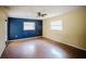 Living room features wood flooring, ceiling fan, and two windows at 585 Gasline Rd, Deland, FL 32724