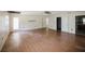 Open-concept living area with hardwood floors, natural light from multiple windows, and a view into the kitchen at 585 Gasline Rd, Deland, FL 32724