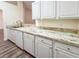Updated kitchen boasts granite countertops, white cabinets, and a stylish faucet at 654 Harbor Villa Ct, Clermont, FL 34711