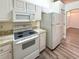 Modern kitchen features white cabinets, granite countertops, and stainless steel appliances at 654 Harbor Villa Ct, Clermont, FL 34711
