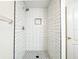 Modern walk-in shower with subway tiles and a geometric floor at 654 Harbor Villa Ct, Clermont, FL 34711
