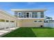 Two-story home with a covered carport and a lush lawn at 6802 S Atlantic Ave, New Smyrna Beach, FL 32169