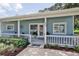 Charming light blue home with a white porch and well-manicured landscaping at 801 E 8Th Ave, New Smyrna Beach, FL 32169
