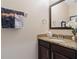 Small bathroom with granite countertop, dark brown vanity, and a mirror at 8112 Roseville Blvd, Davenport, FL 33896