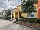 Front view of a two-story townhome with lush landscaping at 8938 Majesty Palm Rd, Kissimmee, FL 34747