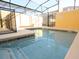 Community pool with a screened enclosure and ample deck space at 8938 Majesty Palm Rd, Kissimmee, FL 34747