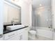 Clean bathroom with a modern vanity, shower/tub combo, and gray tile at 13370 Alderley Dr, Orlando, FL 32832