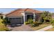 Gray house with a tile roof, driveway, and landscaping at 13370 Alderley Dr, Orlando, FL 32832
