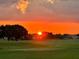 Beautiful community golf course with sunset sky, mature trees, and manicured green lawns at 13370 Alderley Dr, Orlando, FL 32832