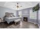 Main bedroom with king bed, fireplace, and ceiling fan at 13832 Riverpath Grove Dr, Orlando, FL 32826