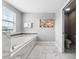 Relaxing bathroom with soaking tub, walk-in shower, and marble floors at 1555 Palmero Way, Davenport, FL 33896