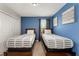 Bedroom with twin beds and blue walls at 1555 Palmero Way, Davenport, FL 33896