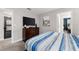 Bedroom with striped bedding and built-in TV at 1555 Palmero Way, Davenport, FL 33896