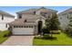 Two-story house with stone accents and a three-car garage at 1555 Palmero Way, Davenport, FL 33896