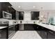 Modern kitchen with black cabinets and white quartz countertops at 1555 Palmero Way, Davenport, FL 33896