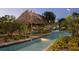 Relaxing lazy river with a thatched-roof hut at 1555 Palmero Way, Davenport, FL 33896