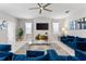 Open living area showcasing stylish blue sofas and a large TV at 1555 Palmero Way, Davenport, FL 33896