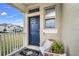 Cozy front porch with blue door and wicker seating at 15657 Pelican Cay Dr, Winter Garden, FL 34787