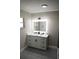 White vanity with marble countertop and LED mirror at 17211 Se 160Th Avenue Rd, Weirsdale, FL 32195