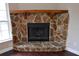 Stone fireplace with a wooden mantel at 17211 Se 160Th Avenue Rd, Weirsdale, FL 32195