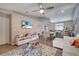 Bright living room features a ceiling fan, neutral walls, television, and an open floor plan to the dining area at 1748 Christina Lee Lane, St Cloud, FL 34769