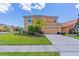 Two-story house with a two-car garage and nicely landscaped lawn at 2501 Dharma Cir, Kissimmee, FL 34746