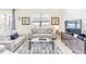 Bright living room featuring two sofas, coffee table, and large TV at 2501 Dharma Cir, Kissimmee, FL 34746
