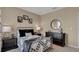 Bedroom with metal bed frame, checkered comforter, and black dresser at 2522 Sage Valley Way, Winter Haven, FL 33884