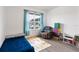 Bright bedroom with hardwood floors, a lounger, and natural light from a large window at 3627 Crimson Clover Dr, Mount Dora, FL 32757