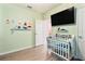 Serene bedroom with crib and large TV at 3627 Crimson Clover Dr, Mount Dora, FL 32757