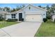 Charming one-story home with light blue siding, a two-car garage, and a well-manicured lawn at 3627 Crimson Clover Dr, Mount Dora, FL 32757