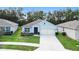 Single-story home with light blue exterior, two-car garage, and landscaped front yard at 3627 Crimson Clover Dr, Mount Dora, FL 32757