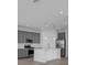 Modern kitchen with gray cabinets, white island, and stainless steel appliances at 368 Belmond Dr, Debary, FL 32713