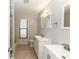 Bathroom featuring double sinks, a glass-enclosed shower, and bright lighting fixtures at 512 Holbrook Cir, Lake Mary, FL 32746