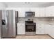 Renovated kitchen featuring stainless steel appliances, sleek cabinets, and a stylish backsplash at 512 Holbrook Cir, Lake Mary, FL 32746