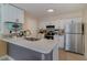 White kitchen with stainless steel appliances and an island at 5158 Twine St, Orlando, FL 32821