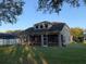 Tan house with large screened porch and fenced backyard at 6344 Earthgold Dr, Windermere, FL 34786