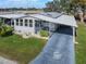 Single-wide manufactured home with carport and landscaped yard at 6375 Lolly Bay Ne Loop, Winter Haven, FL 33881