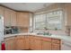 Kitchen with light wood cabinets, double sink, and corner workstation at 6375 Lolly Bay Ne Loop, Winter Haven, FL 33881