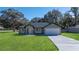 Newly constructed home with a green exterior, gray roof, and a paved driveway at 6455 Hemlock Rd, Ocala, FL 34472