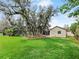 Lush backyard with a play structure shaded by mature trees, perfect for relaxation at 647 Saranac Dr, Winter Springs, FL 32708