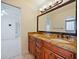 Bathroom featuring a dual sink vanity with granite countertops, tile flooring, and dark wood cabinets at 647 Saranac Dr, Winter Springs, FL 32708