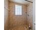 Walk-in shower featuring tan tiling, built in shelving, and decorative glass block window at 647 Saranac Dr, Winter Springs, FL 32708